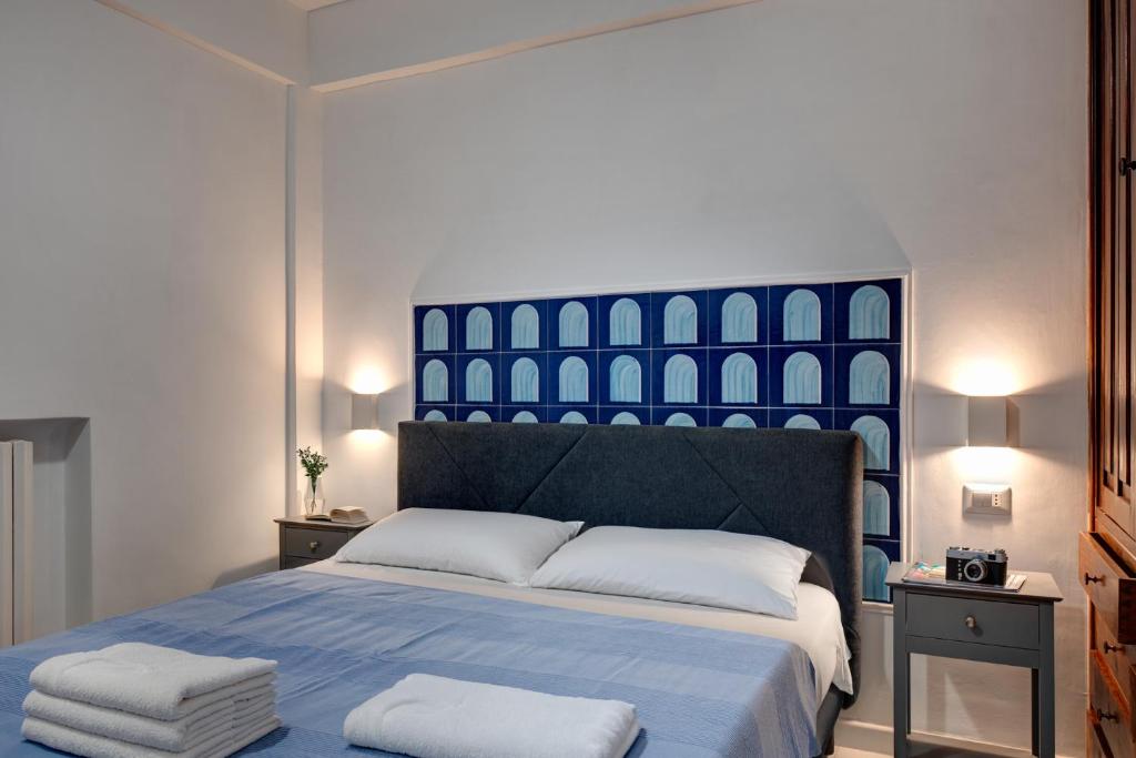 Letto matrimoniale con testata imbottita e decorazione blu sulla parete