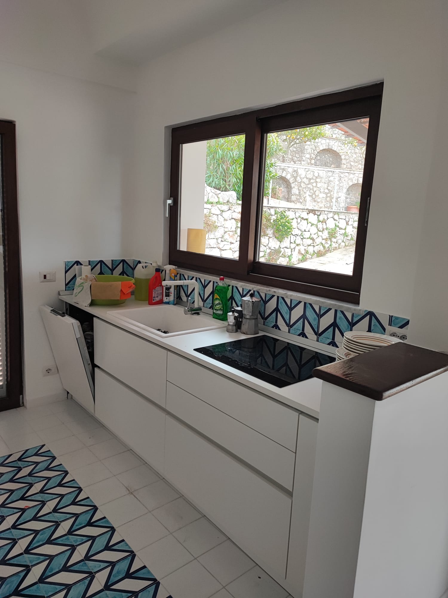 La cucina di Villa Demetra con piano cottura, lavello e decorazioni blu
