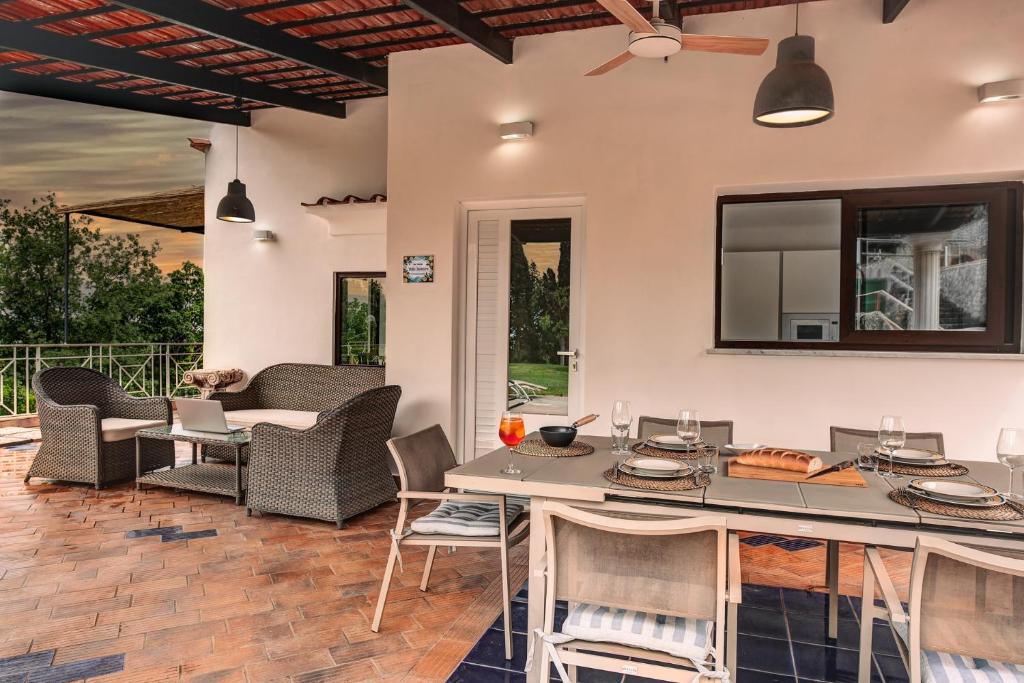 Il patio coperto di Villa Demetra con tavolo da pranzo e salotto esterno